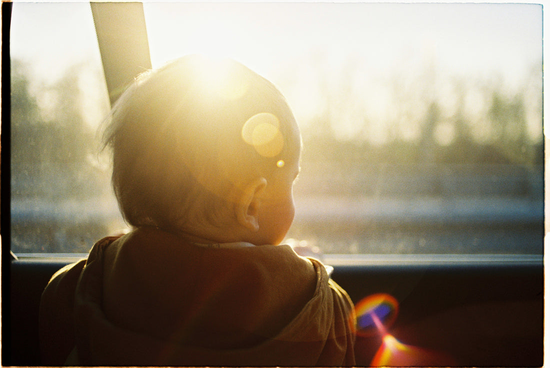 Young child looking out window at sunset | Safe Sleep Space