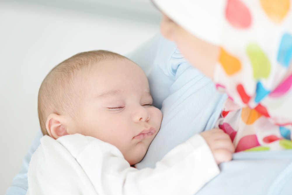 sleeping baby held by mother